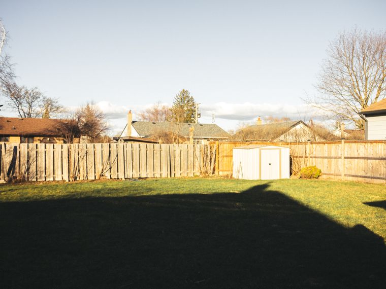 Wood privacy fence enclosing a large suburban back lawn